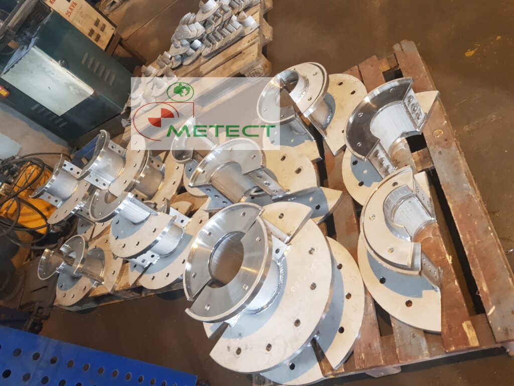 Các nửa đai kẹp cáp biển bằng thép không gỉ, mặt bích có lỗ bu lông, xếp trên pallet gỗ tại xưởng METECT. Ảnh chụp thực tế năm 2021.
